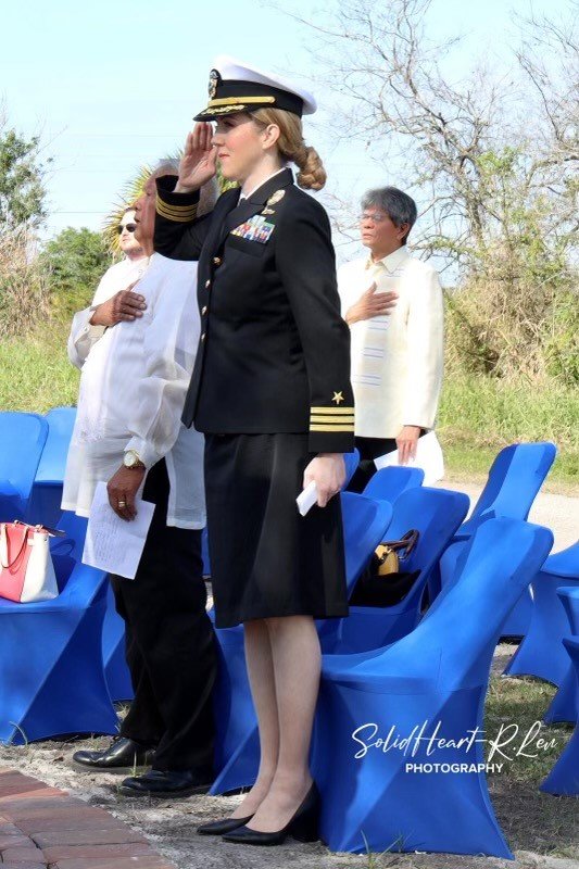 Philippines and U.S. Flags are raised during ceremony dedicating Memorial Park. Saluting is Pentagon Spokesperson Navy Commander Jessica McNulty , along with PACFF Inc Executive Director , Mr. Sid Estrada (right of Commander McNulty ) and PACFF Inc. President & Chair, Dr. Gerard Flores ( second back row).
